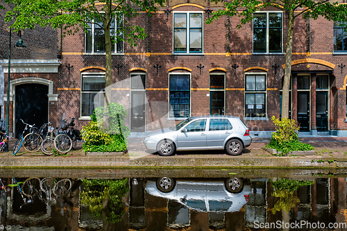 Image of Cars on canal embankment in street of Delft. Delft, Netherlands