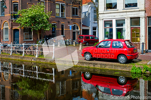 Image of Cars on canal embankment in street of Delft. Delft, Netherlands