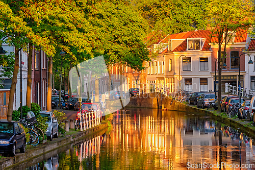 Image of Delt canal with old houses and cars parked along on sunset