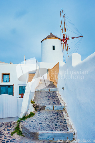 Image of Old greek windmill on Santorini island in Oia town with stairs in street. Santorini, Greece