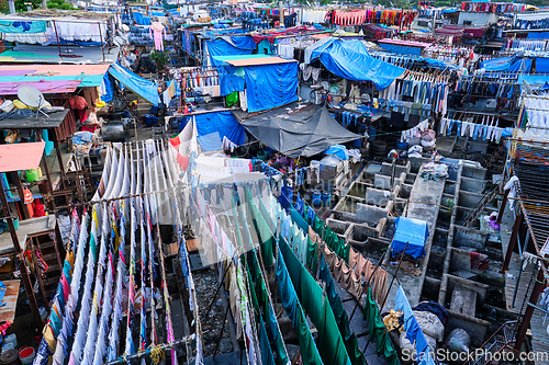 Image of Dhobi Ghat is an open air laundromat lavoir in Mumbai, India with laundry drying on ropes