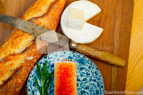 Image of French cheese and fresh  baguette on a wood cutter