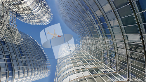 Image of Plane flying over modern office glass skyscrapers