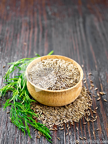 Image of Cumin seeds in bowl with herbs on table