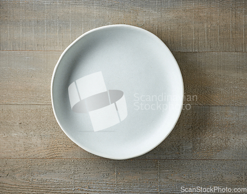Image of empty plate on wooden table