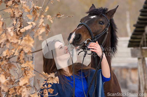 Image of Close-up portrait of a horse and a beautiful girl of Slavic appearance