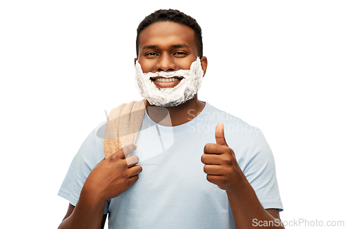 Image of smiling african man with shaving foam and towel