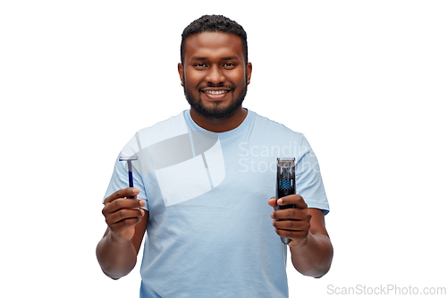 Image of smiling african man with razor blade and trimmer