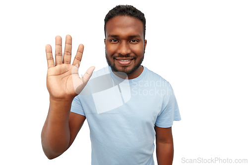 Image of smiling african american young man waving hand
