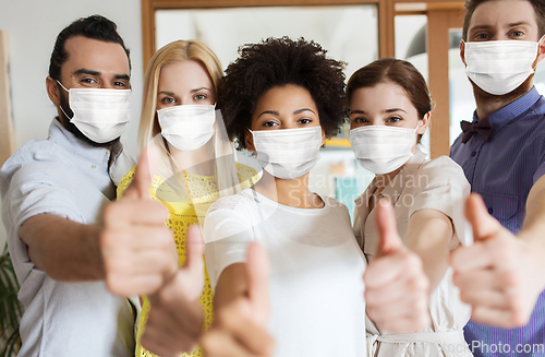 Image of people in masks showing thumbs up at office