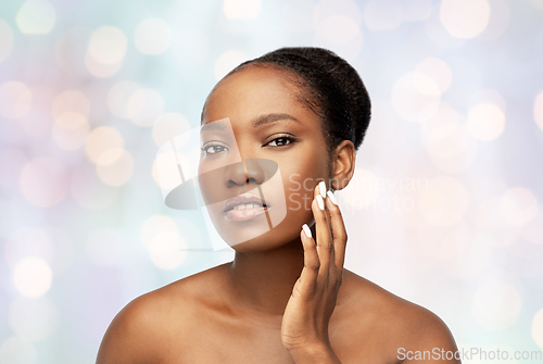 Image of portrait of african woman touching her face