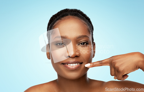 Image of african american woman pointing to her mouth