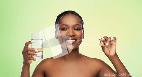 Image of african woman with cod liver oil and water glass