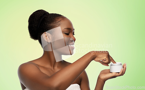 Image of smiling african american woman with moisturizer