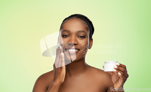 Image of smiling african american woman with moisturizer