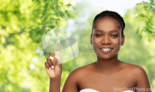 Image of smiling african american woman with moisturizer