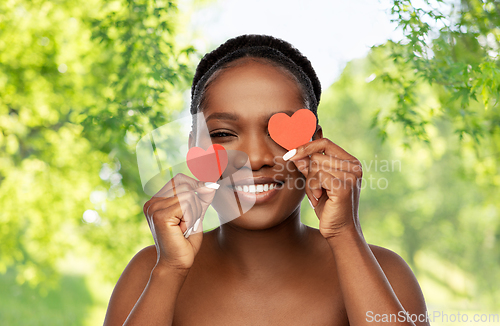 Image of smiling african american woman with red hearts