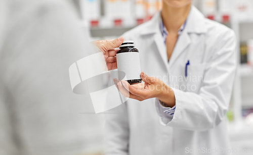 Image of pharmacist and customer with medicine at pharmacy