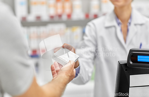 Image of pharmacist and customer with medicine at pharmacy