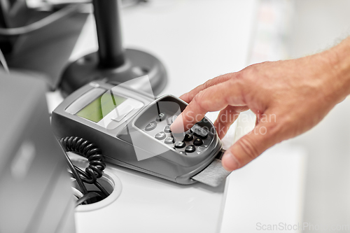 Image of close up of hand with credit card in card-reader