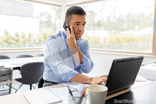 Image of man calling on smartphone at home office