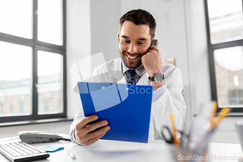 Image of male doctor calling on desk phone at hospital