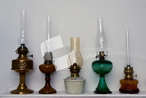 Image of five vintage kerosene lamps on a shelf 