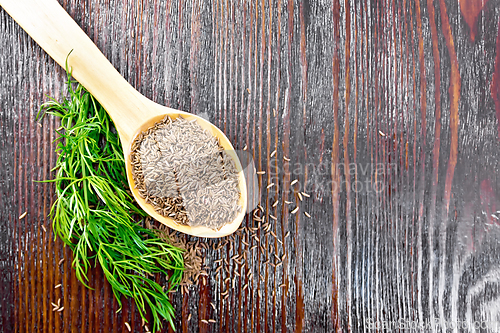 Image of Cumin seeds in spoon with herbs on board top