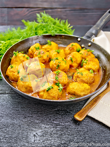 Image of Meatballs in pan with tomato sauce on board