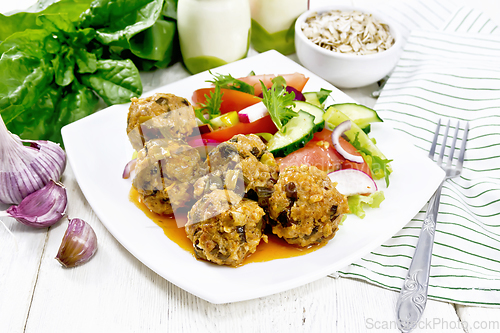 Image of Meatballs with spinach and oatmeal on wooden table