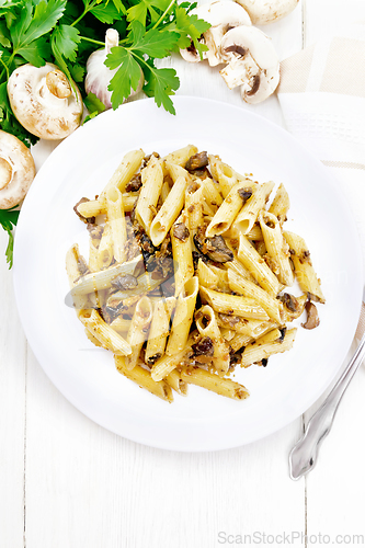 Image of Pasta with mushrooms in white plate on light board top