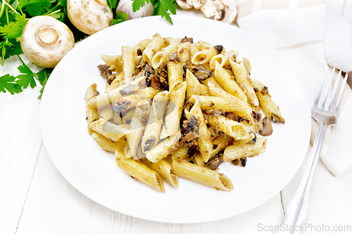 Image of Pasta with mushrooms in white plate on wooden board