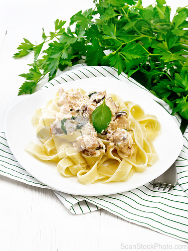 Image of Pasta with salmon in cream on light wooden board