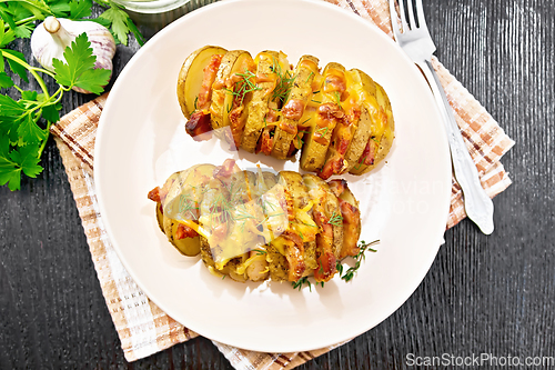 Image of Potatoes with smoked bacon in plate on dark board top