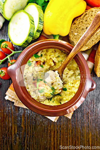 Image of Rice with chicken and vegetables in pot on board top