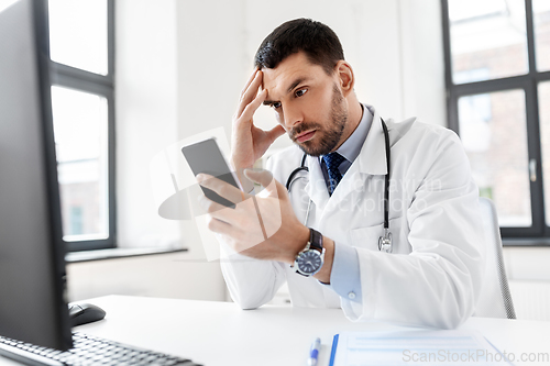 Image of male doctor with smartphone at hospital