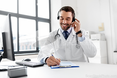 Image of happy doctor with computer and headset at hospital