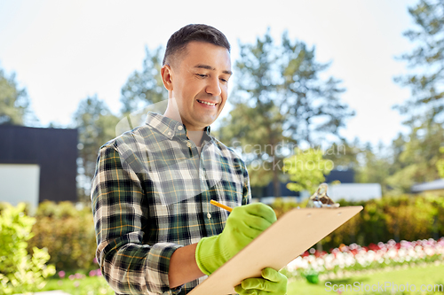 Image of happy man with clipboard at summer garden