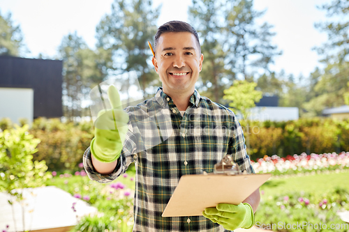 Image of man with clipboard showing thumbs up at garden