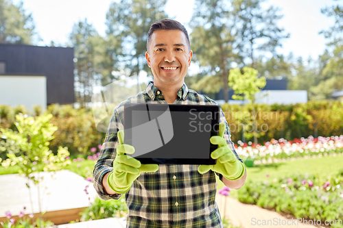 Image of happy middle-aged man showing tablet pc at garden