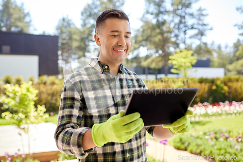 Image of man with tablet pc at summer garden