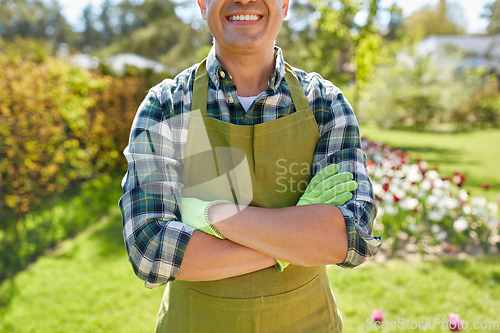 Image of happy man in apron at summer garden