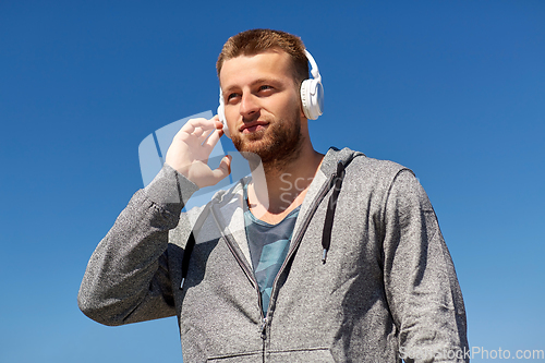 Image of man in headphones listening to music outdoors