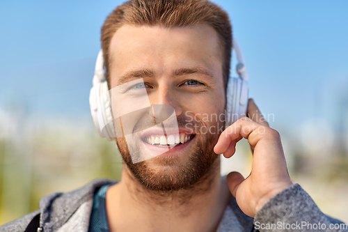 Image of man in headphones listening to music outdoors