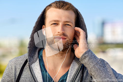 Image of man in earphones listening to music outdoors