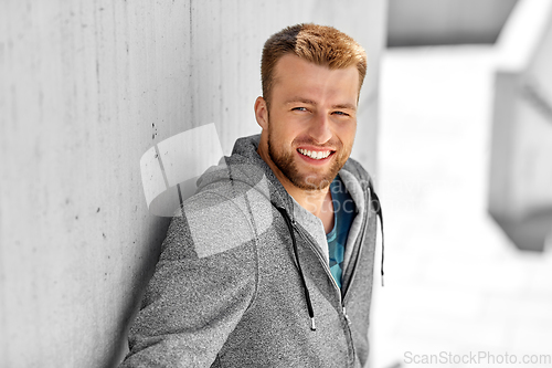 Image of portrait of happy smiling young man outdoors