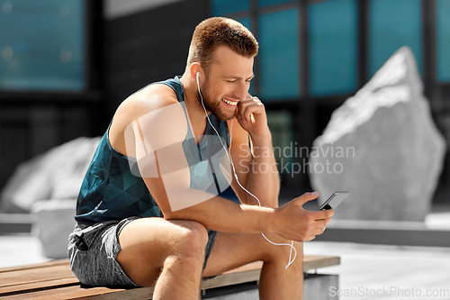 Image of young athlete man with earphones and smartphone