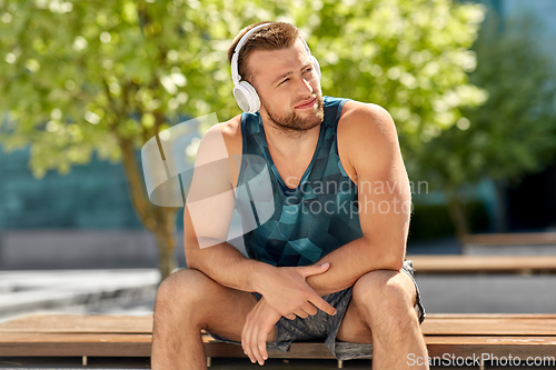 Image of man in headphones listening to music outdoors