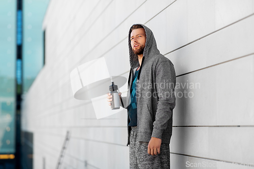 Image of sportsman with bottle of water in city