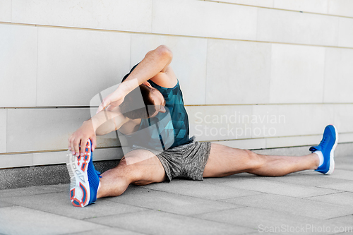 Image of man doing sports and stretching outdoors